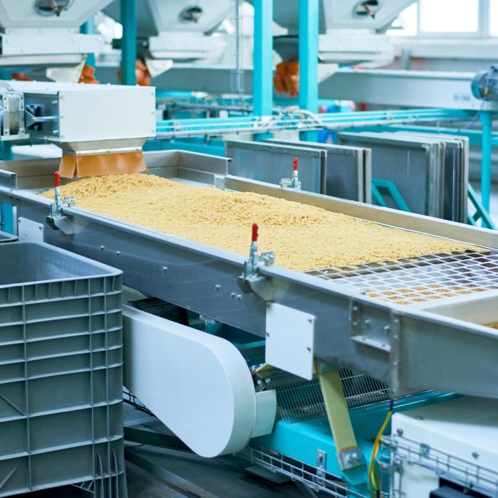Macaroni Production Line Crop shot of production process at modern food factory, focus on conveyor machine unit sorting macaroni, copy space